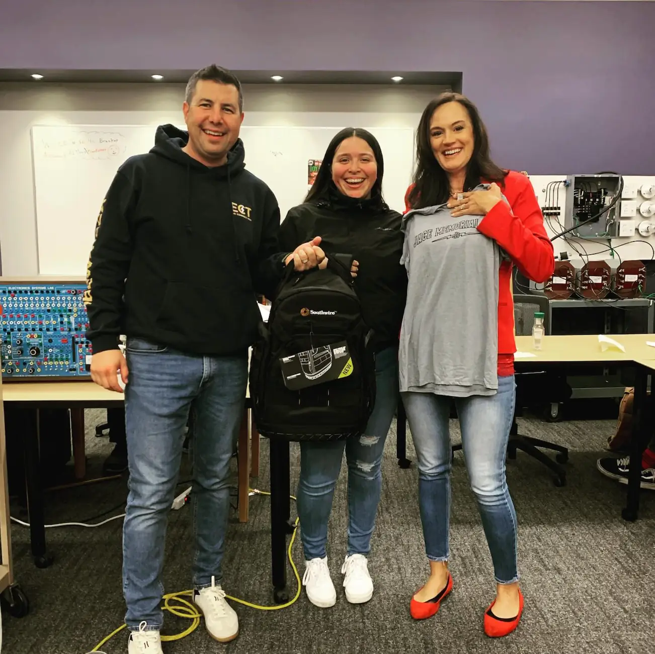 Angie, the first apprentice to receive a Jace Memorial Fund backpack, smiling with fund representatives.